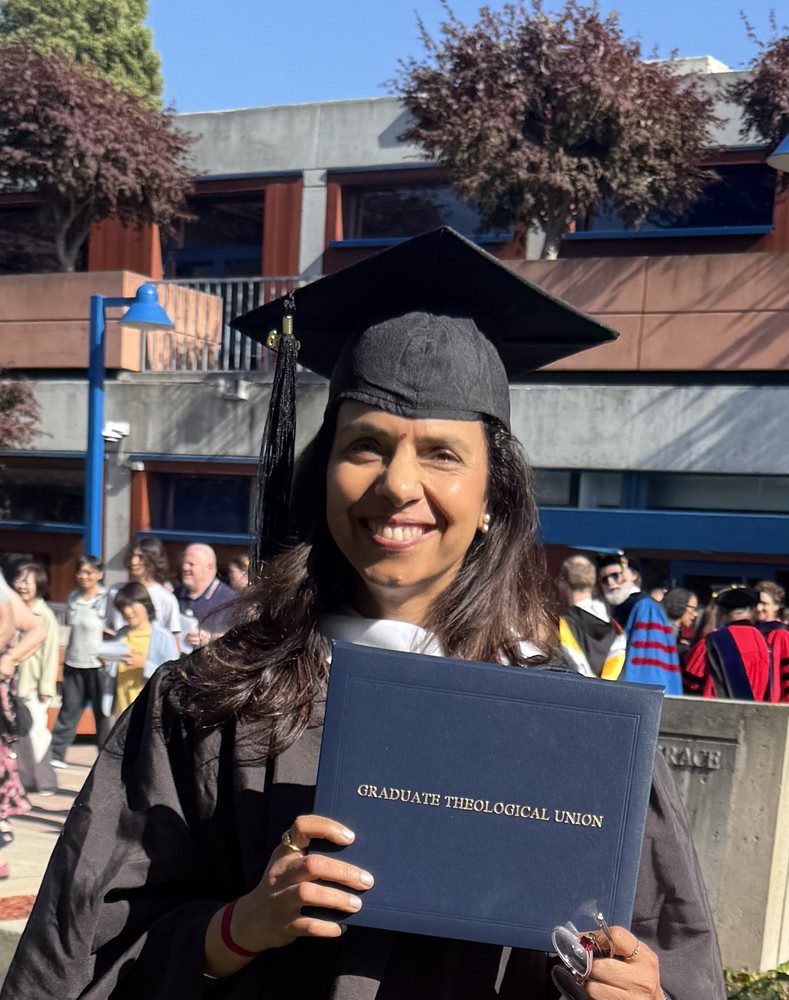 Neeti Soota holding her diploma at the Graduate Theological Union commencement, May 2026